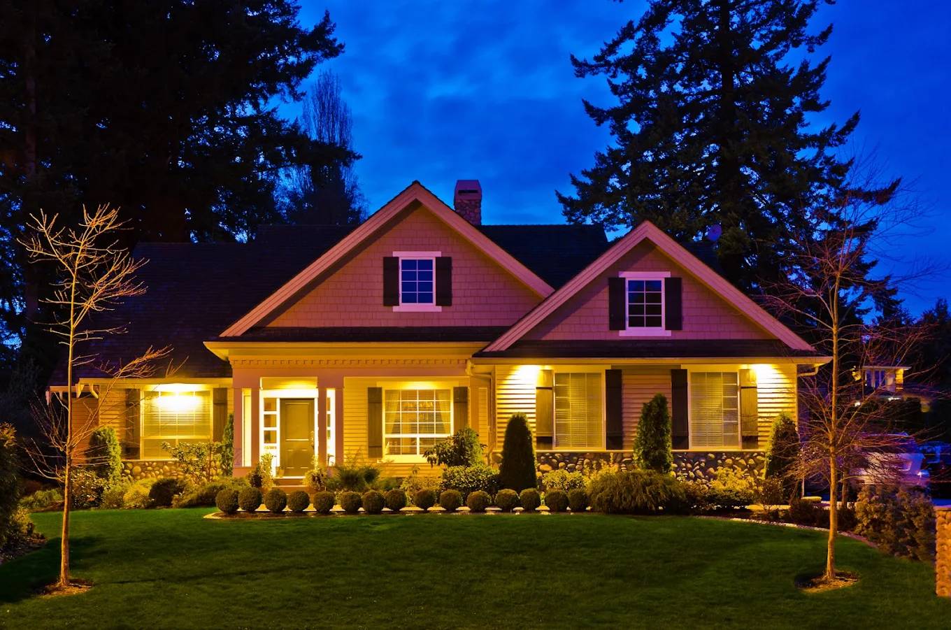 Home at night with warm landscape lighting
